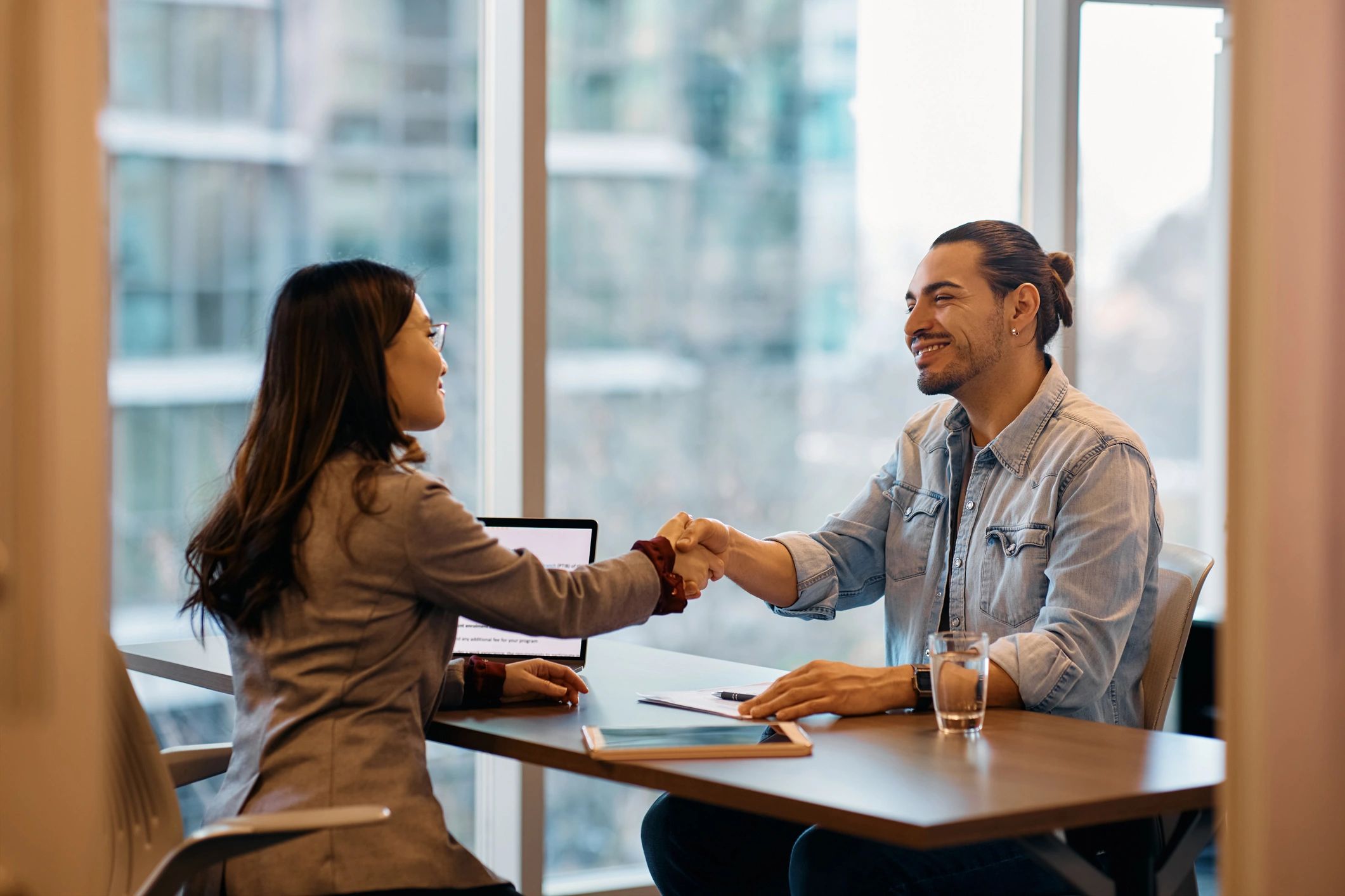 Professionals shaking hands at desk
